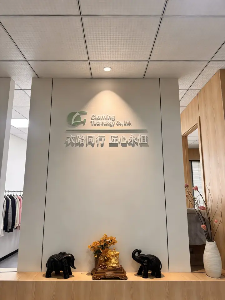 Apparel showroom reception area with sample garments and wall signage