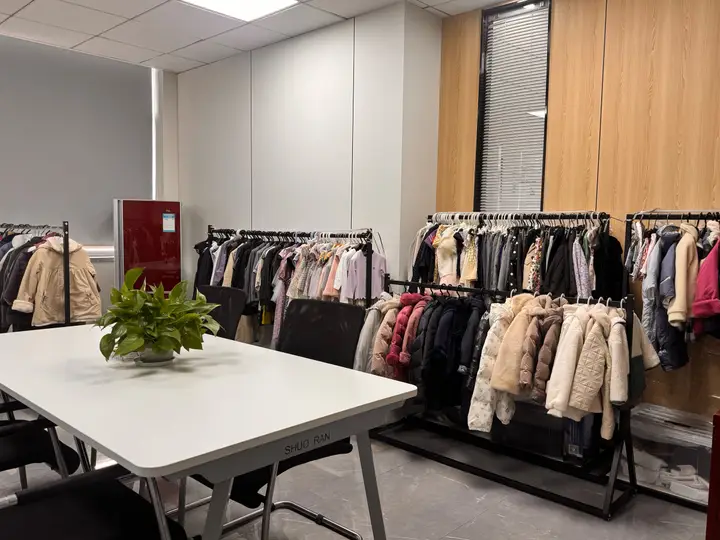 Apparel sample room with children’s and adult garments on racks