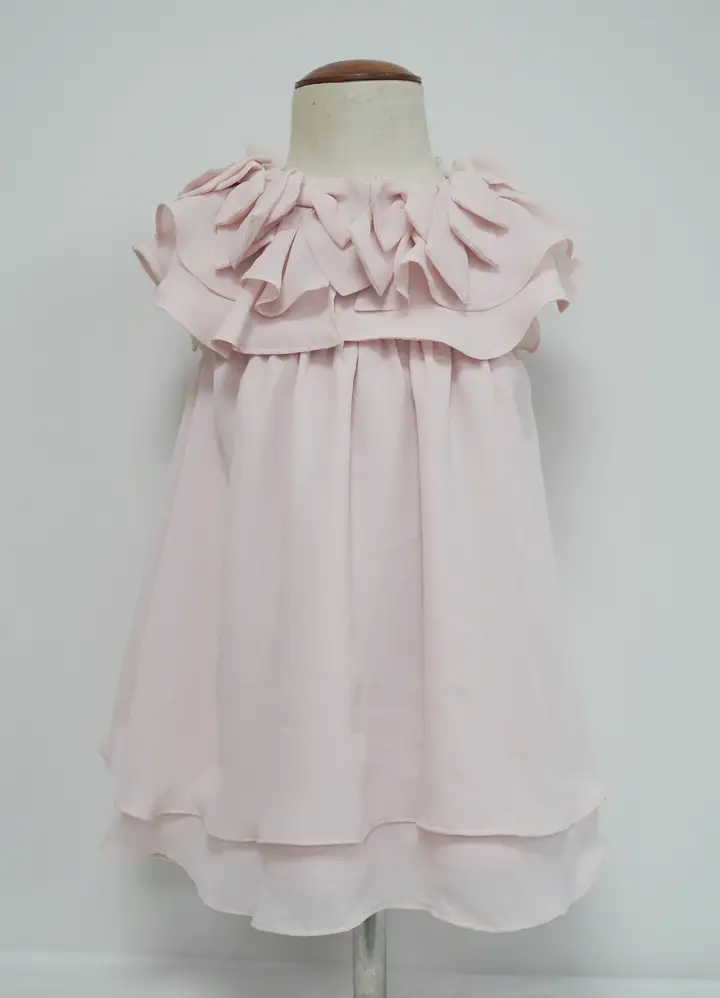 Pale pink children’s sleeveless dress with a layered ruffle neckline