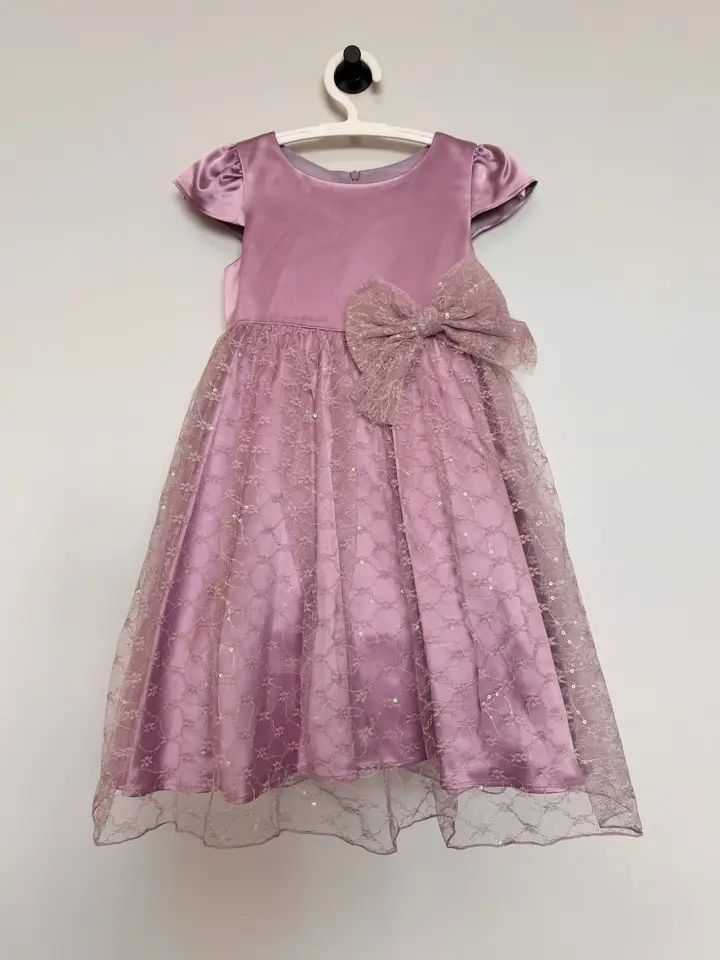 Mauve children’s dress with a satin bodice, lace skirt, and oversized bow