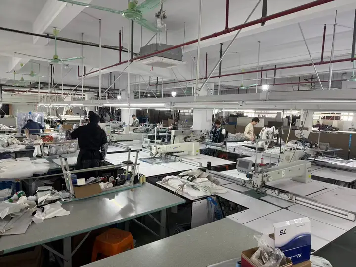 Garment sewing floor with specialized sewing machines and worktables