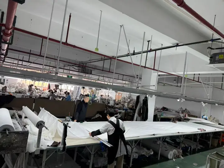 Fabric preparation table with material rolls and laid fabric